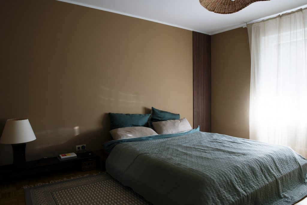 Erdendes Schlafzimmer in Beige- und Grüntönen mit dunklem Holz und einem tiefen japanischen Bett.